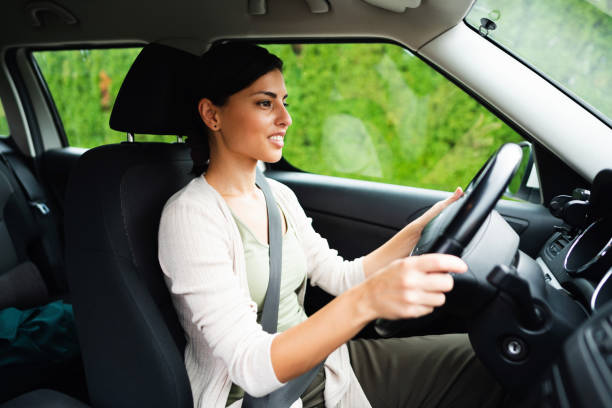 istock Young woman in a car driving 1297310735