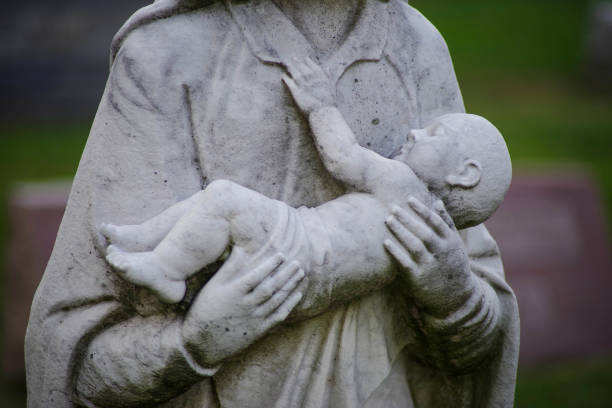 istock Dead infant cemetery stature cradled by loving arms 1297319205