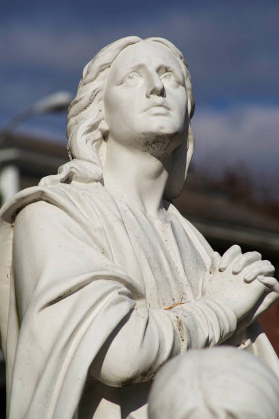 istock Praying saint cemetery stature with clasped hands. 1297319694