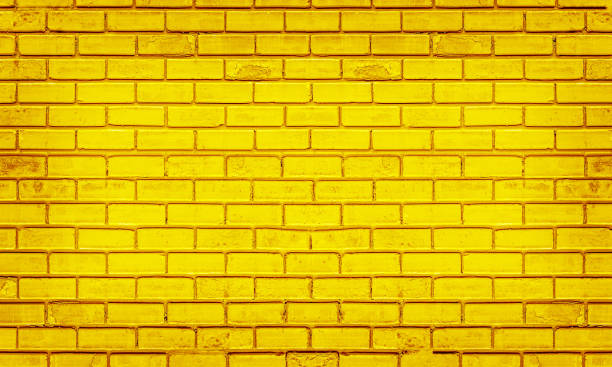 istock Colorful brick wall, bright yellow vintage style of brickwork background 1297322744