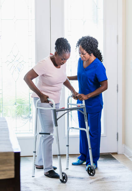 istock Home nurse helping senior woman at home using walker 1297322820