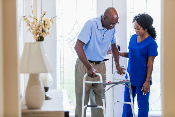 istock Home nurse helping senior man at home using walker 1297322851