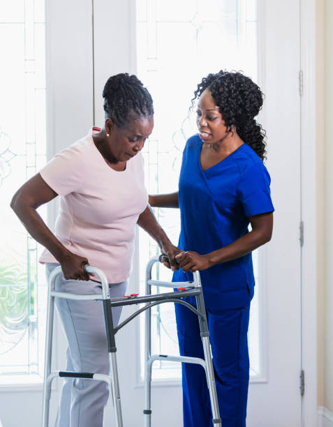 istock Home nurse helping senior woman at home using walker 1297322874