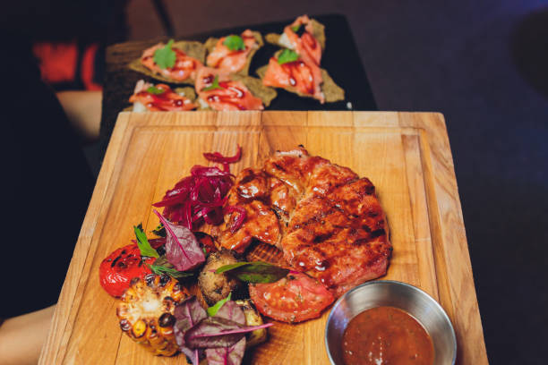 istock Well-done grilled marinated beef flank steak on wooden board. 1297324681