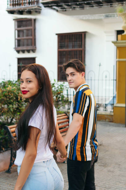 istock Young couple in love walking along a park path 1297326296