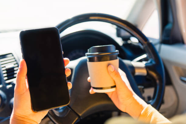 istock woman drinking hot coffee takeaway cup inside a car and using smartphone 1297330484