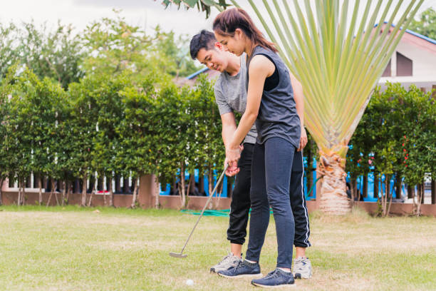istock young man support teaching training woman to play perfect golf while standing together 1297330548