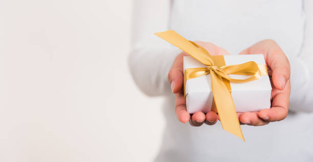 istock Woman beauty hands holding small gift package box present 1297330565