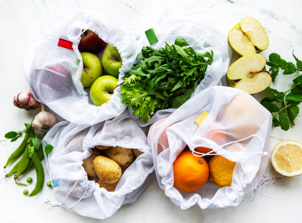 istock Fruits and summer vegetables in reusable eco friendly mesh bags on marble background. Zero waste shopping. Ecological concept. 1297330685