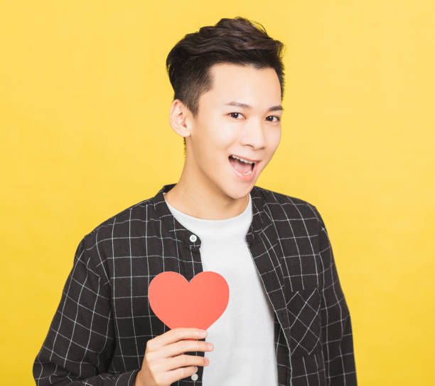 istock excited young man holding Valentines Day red heart sign 1297331396