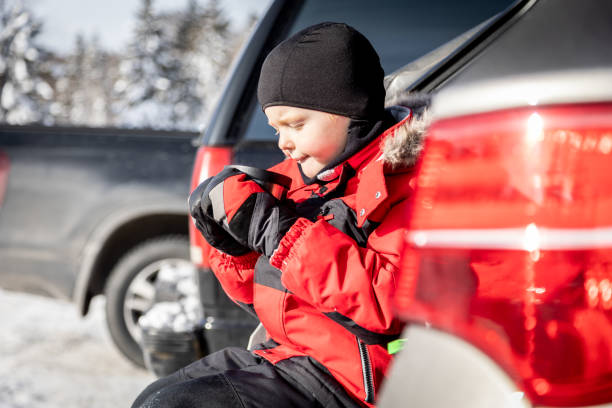 little boy drinking hot chocolate at the car after skiing - ski resort winter sport apres ski ski slope imagens e fotografias de stock