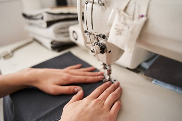 istock Woman seamstress sitting and sews 1297331752