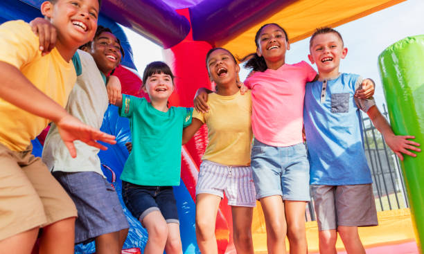 istock Multi-ethnic children in a bounce house 1297335495