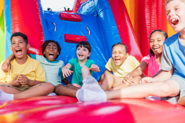 istock Multi-ethnic children in a bounce house 1297335530