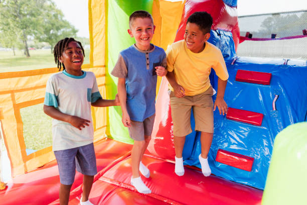 istock Multi-ethnic boys playing in bounce house 1297335585
