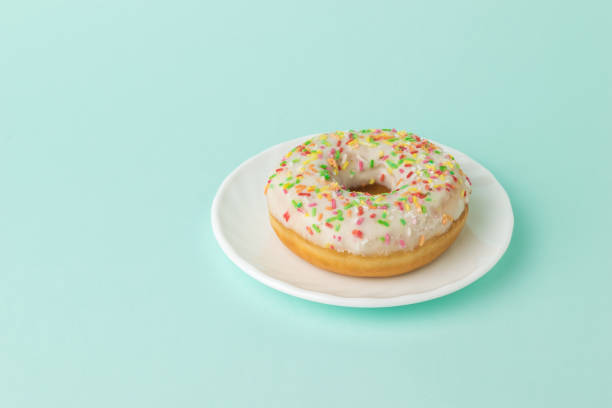 istock Glazed donut on a white plate on a blue background. 1297341383