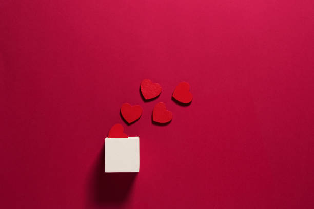 istock Valentine's day composition with gift box and red hearts on red background 1297341414