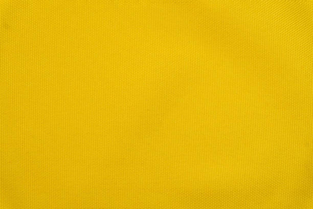 istock Bright yellow background made of textile material. Fabric with natural texture. Fabric isolated background 1297346554