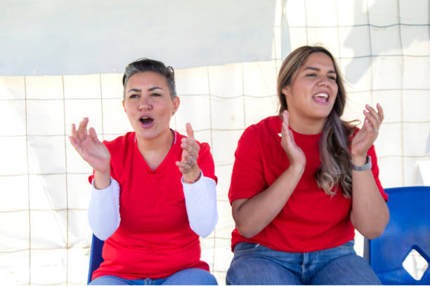 mères encourageant des filles dans les stands - sport parent bleachers family photos et images de collection