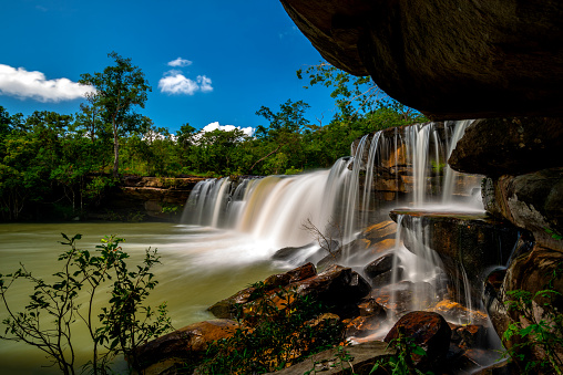 A small waterfall in the deep forest of the border of Thailand and Cambodia,Wang Yai  waterfall in tropical forest,Sisaket province,Thailand. Leaf moving low speed shutter blur.