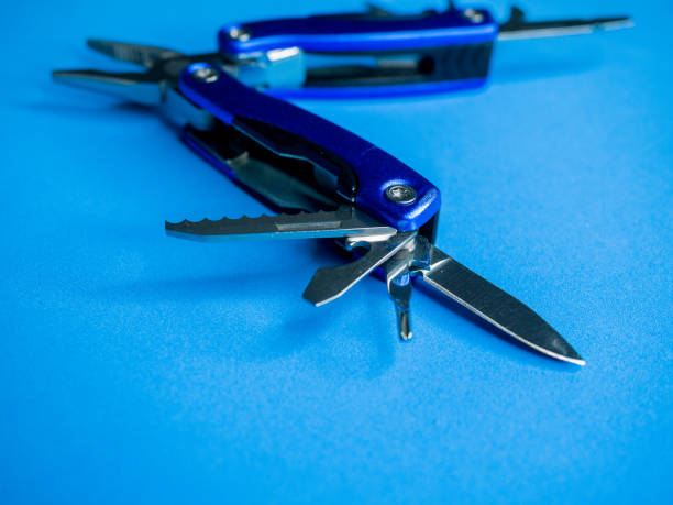 istock Closeup shot of a blue utility pocket plier on a blue surface 1297349730