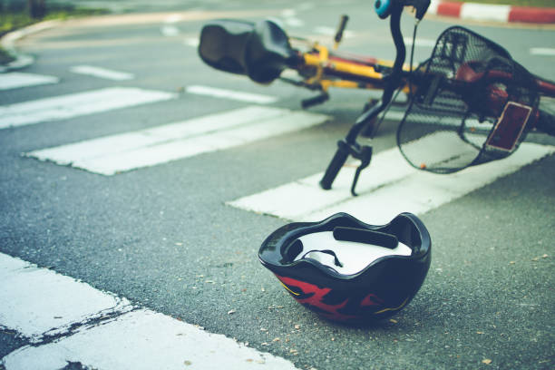 helm und fahrrad liegen nach unfall auf einem fußgängerüberweg auf der straße - unfall ereignis mit verkehrsmittel stock-fotos und bilder