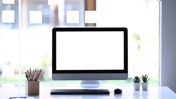 istock Front view of modern computer, stationery and plant on white table. White empty screen for advertise text. 1297358598