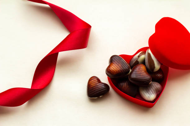 Valentine's Day image of heart-shaped chocolate and red ribbon stock photo