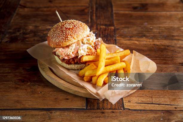 Chicken Burger In Brioche Bun Garnished With Coleslaw Salad Served With Fries Stock Photo - Download Image Now