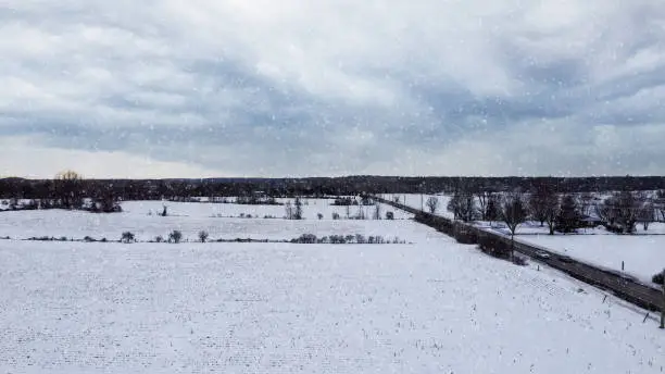 Photo of Aerial view of a corn field covered by snow, snow falling, dark mood, snow storm, near Huntmar Drive in Kanata, ottawa. Ottawa, Ontario, Canada