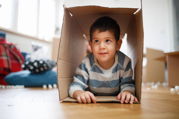 istock Cute toddler lying on front inside an empty box on the floor 1297364203