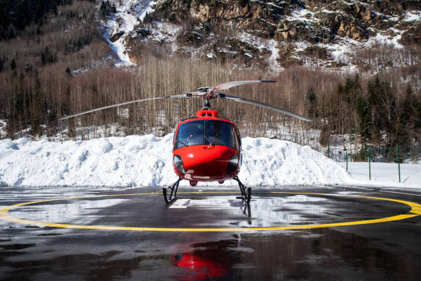 roter kommerzieller hubschrauber am hubschrauber - airfield mountain snow airport stock-fotos und bilder