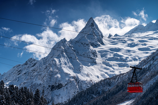 Red vintage cable car and snowcapped mountain peak