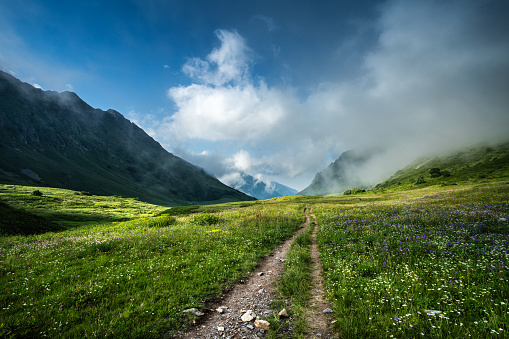 Trail in a mountain valley under the clouds