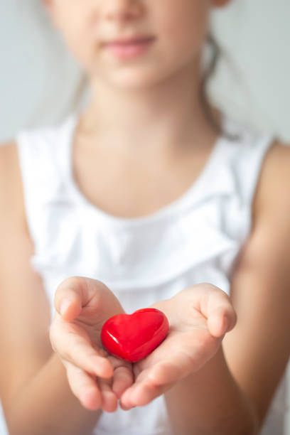 istock Little girl holding a red heart 1297369452