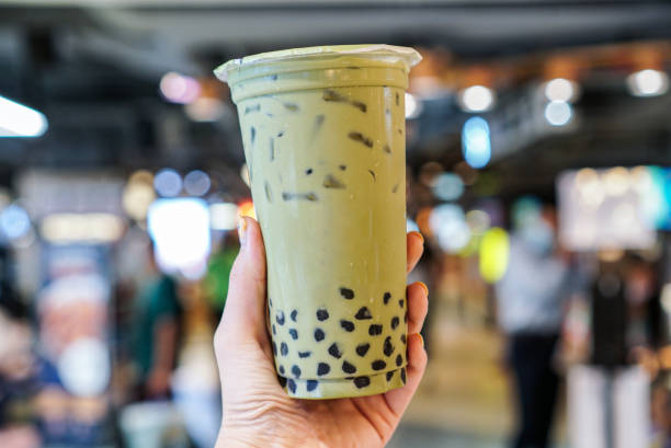 Matcha Green tea Bubble drinks hand holding a plastic cup of matcha green tea with brown sugar bubble or boba or tapioca pearls. bubble tea photos stock pictures, royalty-free photos & images