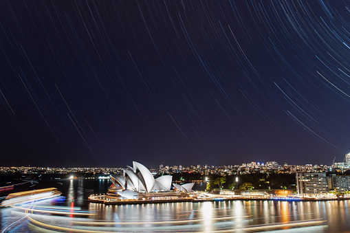 Sydney, Australia - January 9, 2021: Star trail over Sydney Opera House at night.