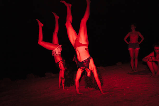 gruppe junger frauen, die sich nachts bei einer seeparty mit roter ampel amüsieren - acrobatic activity flash stock-fotos und bilder