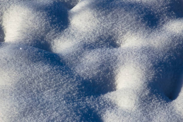 istock Fresh white snow sparkling in the sun with highlights and shadows for background 1297372518