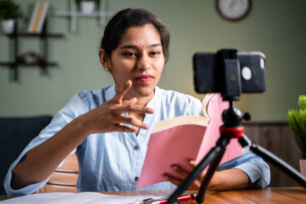 istock Young Girl busy talking with students on mobile phone during online virtual class at home during covid-19 or coronavirus pandemic - Concept of e-teaching, online education 1297372626