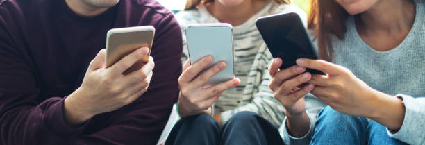 istock Group of young people using and looking at mobile phone while sitting together 1297372661