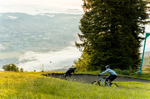 Two mountain bikers riding on grassy hillside