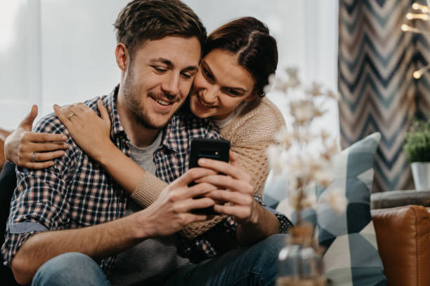 istock Happy young couple relaxing together at home 1297373838