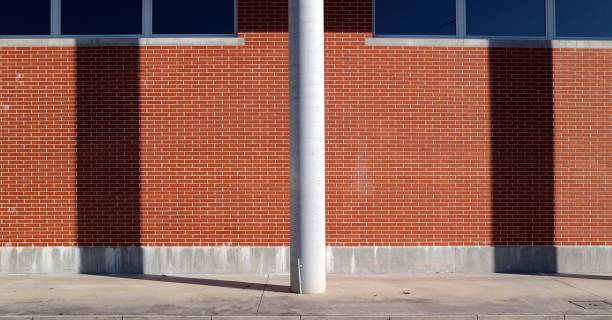 istock White cement column on a concrete pavement in front of a brick wall. 1297374544