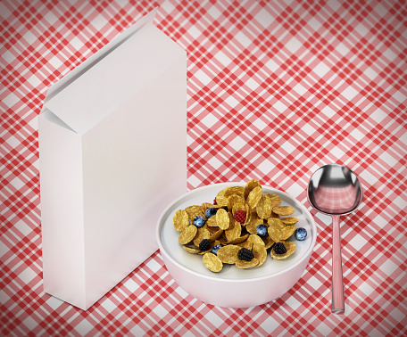 Breakfast cereal with berries, spoon and blank cereal package on tablecloth.