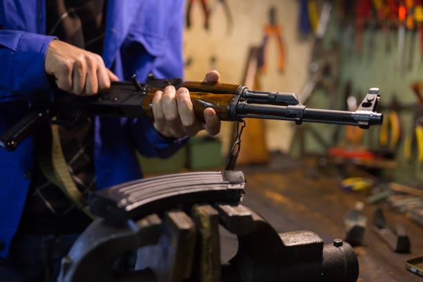 istock Kalashnikov assault rifle in hands of gunsmith in weapons workshop 1297375930