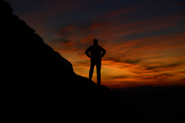 Mount and man silhouette against sunrise background.