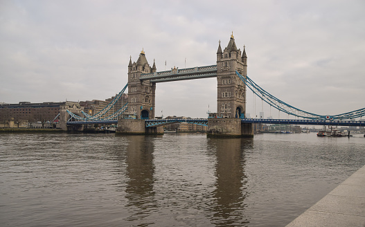 London, United Kingdom - January 15 2021: View of Tower Bridge and River Thames on a grey, cloudy day.