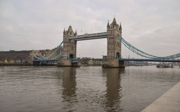 Tower Bridge with overcast sky, London, UK London, United Kingdom - January 15 2021: View of Tower Bridge and River Thames on a grey, cloudy day. waterloo bridge stock pictures, royalty-free photos & images