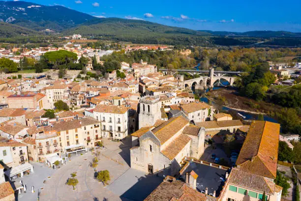 Aerial view of historic centre of Besalu with Romanesque bridge over Fluvia river in sunny fall day, Catalonia, Spain